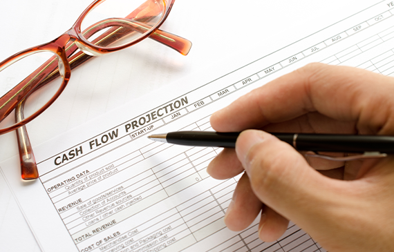 Hand holding a pen while reviewing a cash‑flow projection worksheet next to eyeglasses. Illustrates how Beacon Funding’s equipment financing supports better cash‑flow planning by spreading equipment costs over time, enabling businesses to grow without straining their budget. Hand holding a pen while reviewing a cash‑flow projection worksheet next to eyeglasses. Illustrates how Beacon Funding’s equipment financing supports better cash‑flow planning by spreading equipment costs over time, enabling businesses to grow without straining their budget.